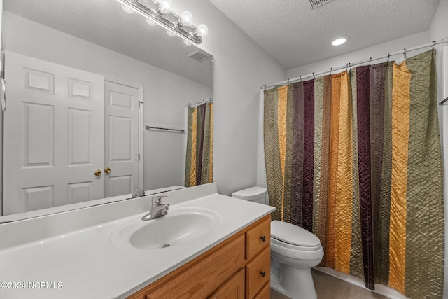 bathroom featuring vanity, toilet, a textured ceiling, and curtained shower