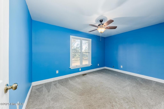 carpeted spare room with ceiling fan