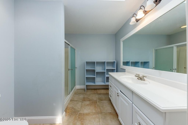 bathroom featuring a shower with shower door and vanity