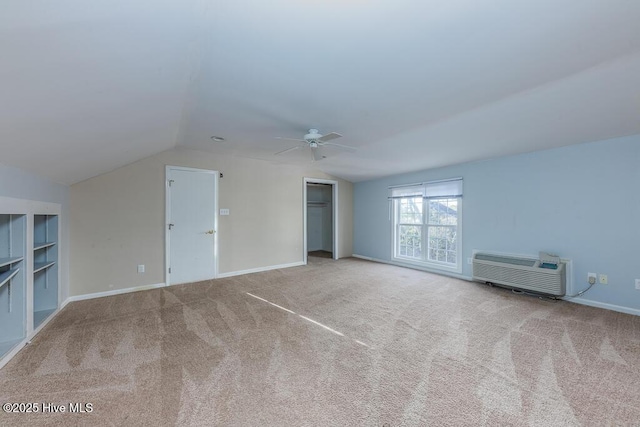 interior space with ceiling fan, light colored carpet, a wall mounted AC, and vaulted ceiling