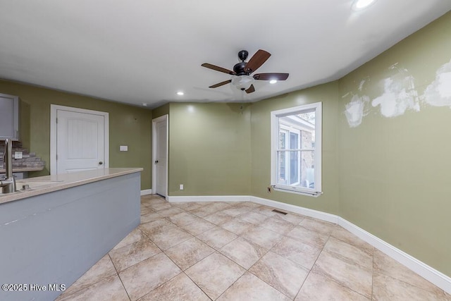 empty room with ceiling fan, sink, and light tile patterned floors