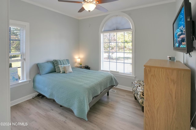 bedroom featuring crown molding, ceiling fan, and light hardwood / wood-style flooring