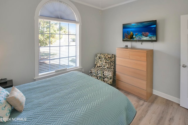 bedroom with crown molding and light hardwood / wood-style floors