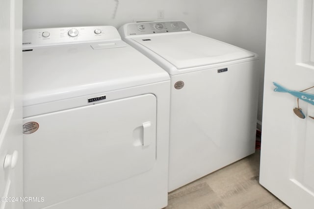 clothes washing area with washer and clothes dryer