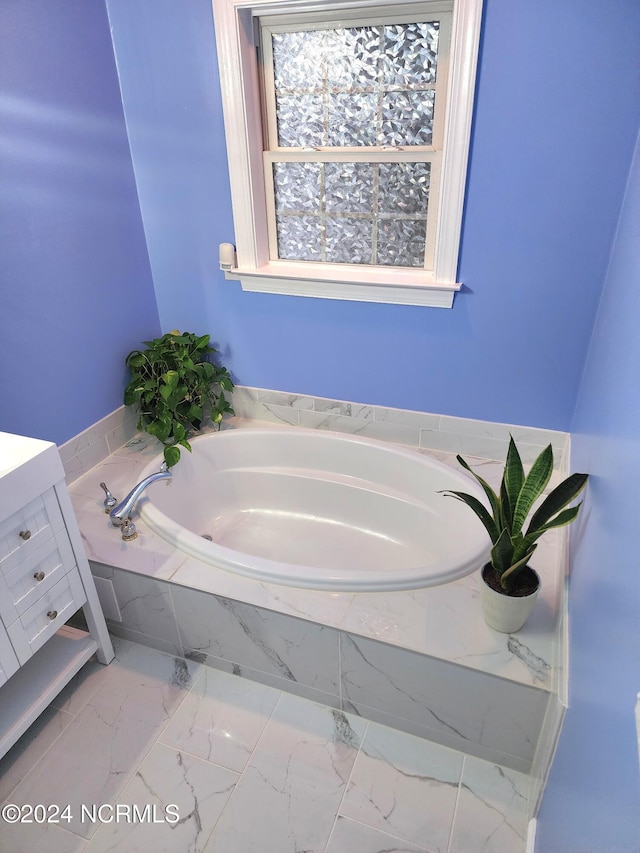 bathroom with vanity and tiled bath