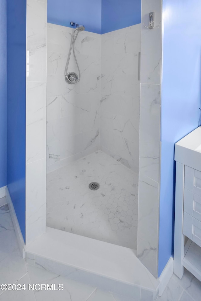 bathroom with vanity and tiled shower