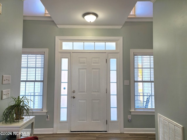 entrance foyer featuring ornamental molding, a healthy amount of sunlight, and hardwood / wood-style floors