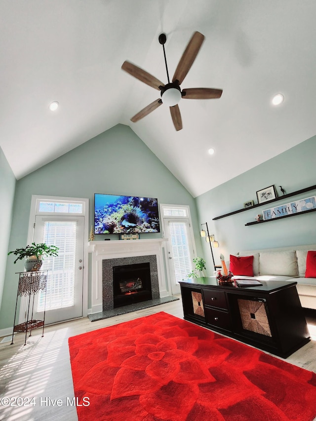 bedroom with multiple windows, access to outside, high vaulted ceiling, and a premium fireplace