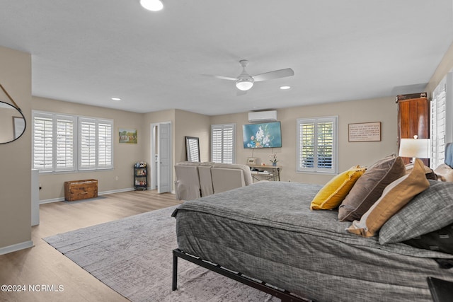 bedroom with recessed lighting, a wall mounted AC, ceiling fan, wood finished floors, and baseboards