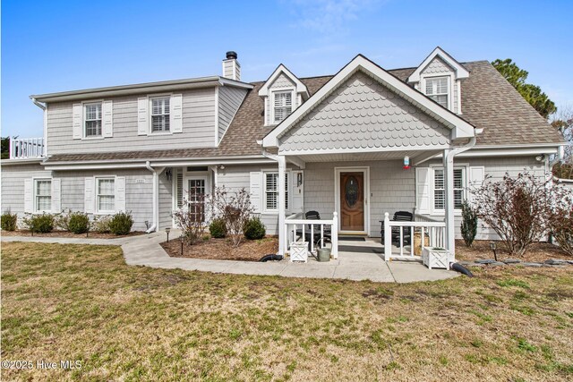 view of front of property with a garage, a front lawn, and a porch