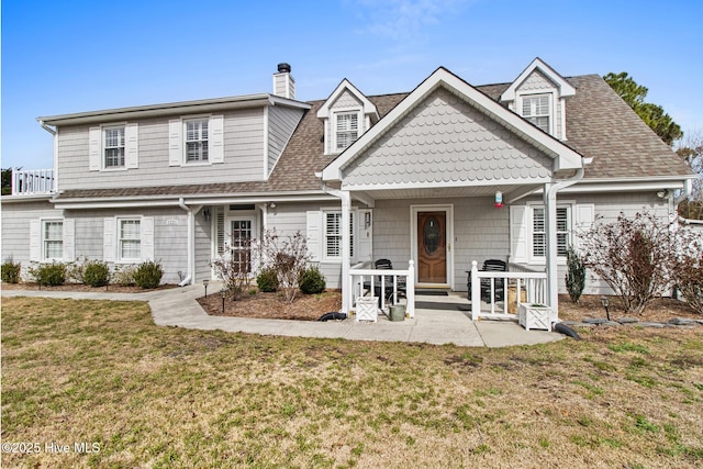 view of front of property with a shingled roof, a chimney, and a front yard