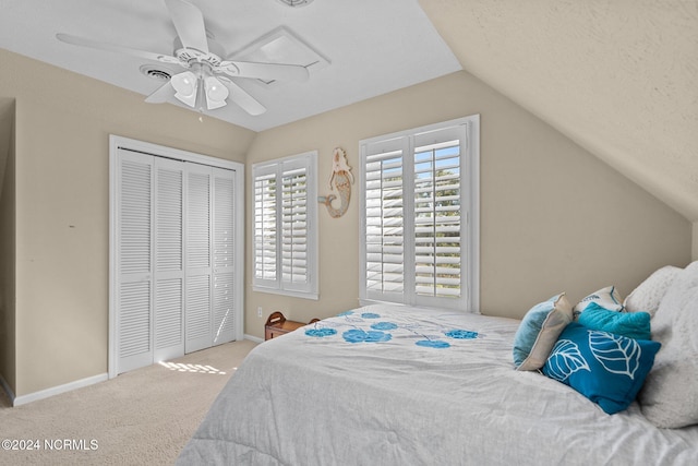 carpeted bedroom featuring a closet, ceiling fan, a textured ceiling, and lofted ceiling