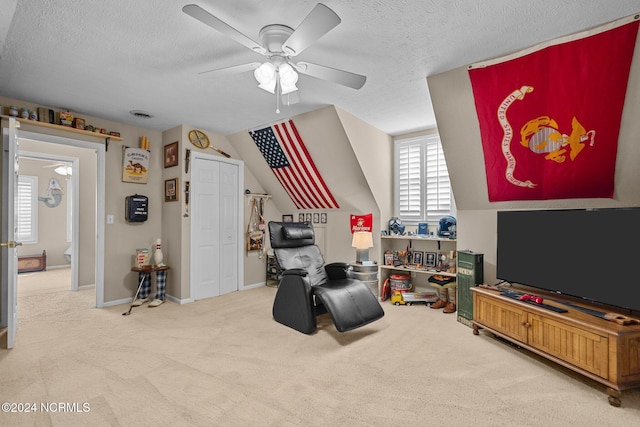 sitting room with a textured ceiling, ceiling fan, and carpet flooring