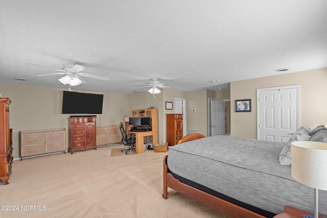 carpeted bedroom with ceiling fan and a textured ceiling