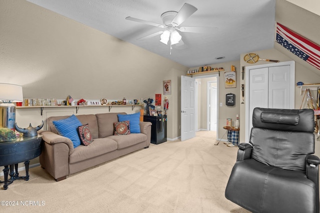 carpeted living room with vaulted ceiling, a textured ceiling, and ceiling fan