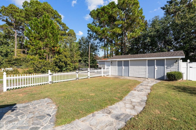 view of yard with fence private yard and an outbuilding