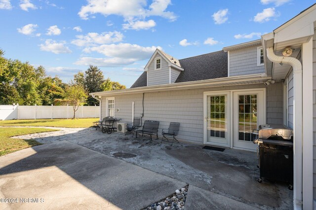 back of property with a yard, central air condition unit, and a patio area