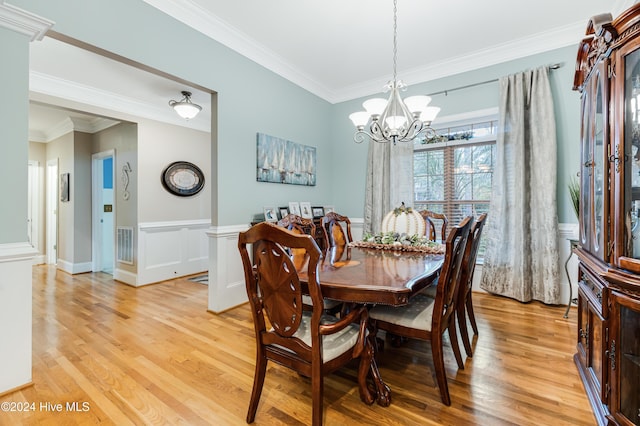 dining space with crown molding, light hardwood / wood-style flooring, and a notable chandelier