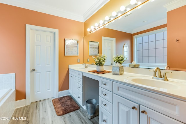 bathroom with tiled tub, vanity, wood-type flooring, and ornamental molding