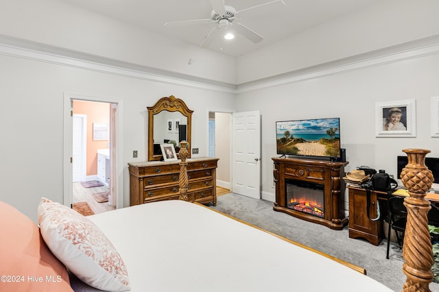 carpeted bedroom with ensuite bathroom and ceiling fan