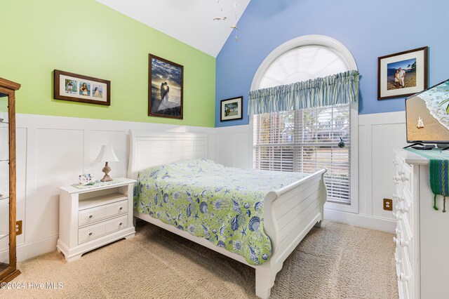 bedroom featuring light carpet and vaulted ceiling