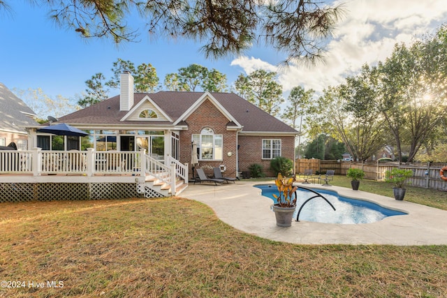 back of property with a yard, a patio, and a pool side deck