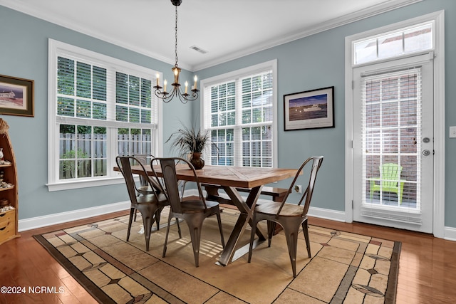 dining room with crown molding, hardwood / wood-style floors, and plenty of natural light