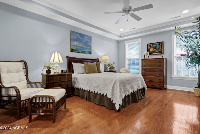 bedroom with multiple windows, wood-type flooring, crown molding, and ceiling fan