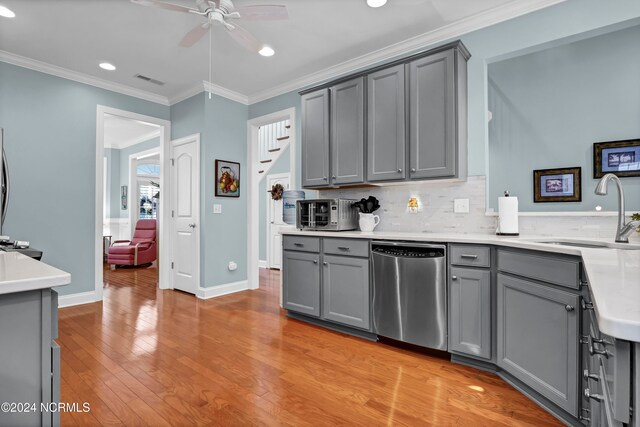 kitchen with sink, dishwasher, gray cabinetry, and light wood-type flooring