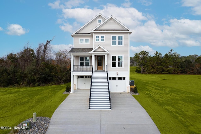 coastal home featuring driveway, an attached garage, and a front lawn