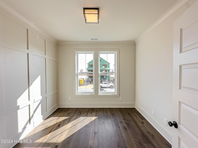 empty room with crown molding and dark hardwood / wood-style flooring