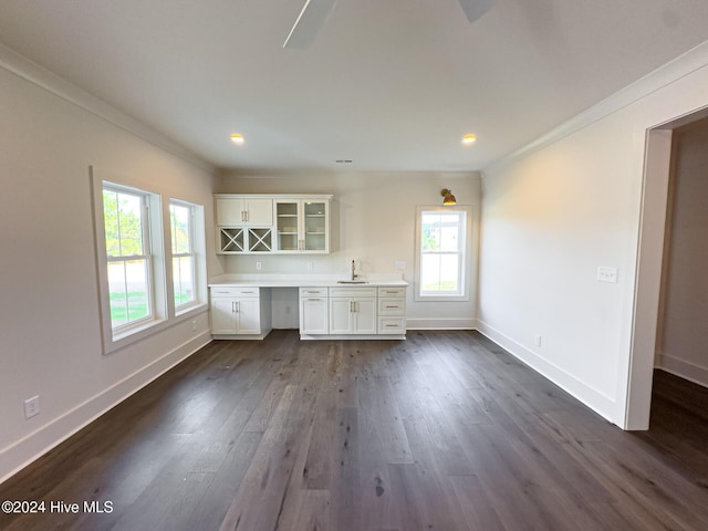 kitchen featuring white cabinets, dark hardwood / wood-style floors, built in desk, and ornamental molding