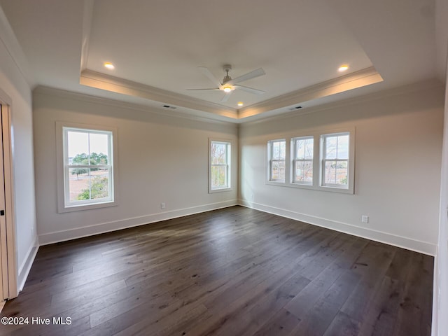 spare room with dark hardwood / wood-style flooring, a raised ceiling, and ornamental molding