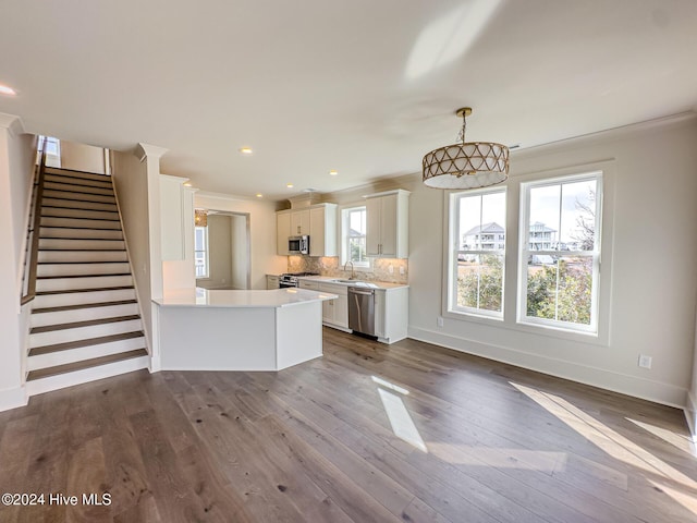 kitchen featuring white cabinetry, stainless steel appliances, tasteful backsplash, crown molding, and decorative light fixtures