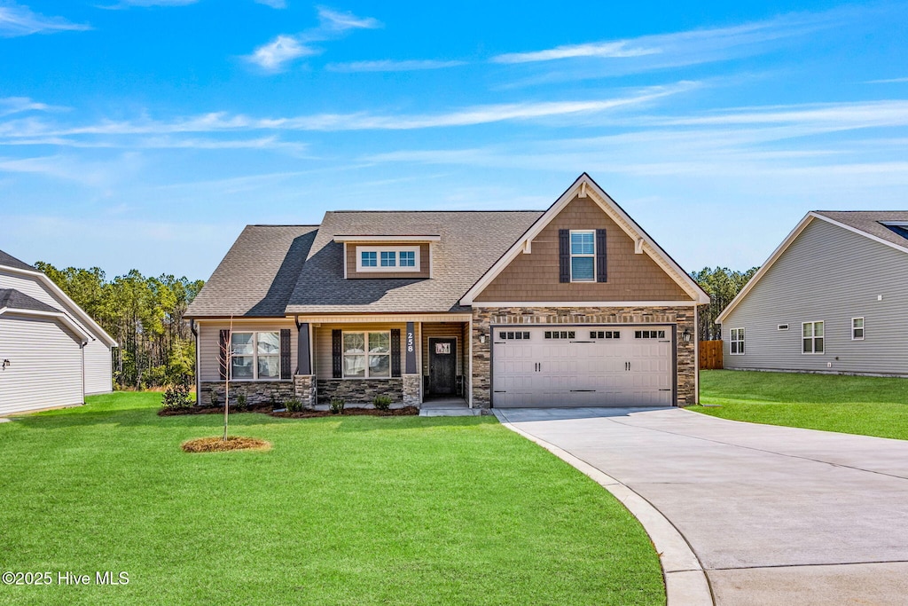 craftsman-style house featuring stone siding, a front lawn, and concrete driveway