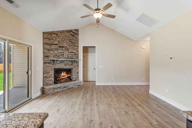 unfurnished living room featuring a stone fireplace, a wealth of natural light, and visible vents