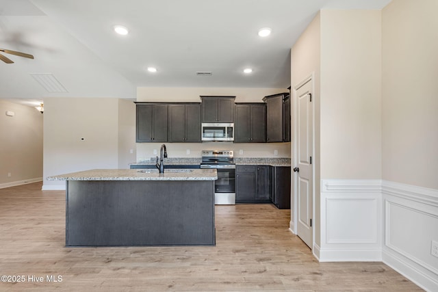 kitchen with appliances with stainless steel finishes, light wood-type flooring, visible vents, and a sink