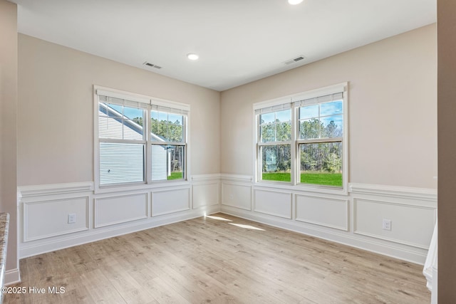 unfurnished room with light wood-style flooring, visible vents, and recessed lighting