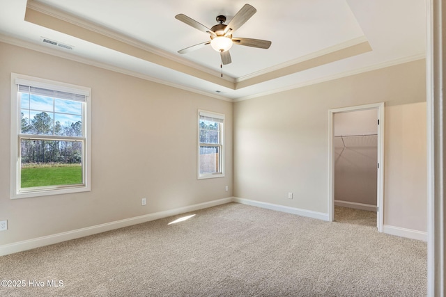 interior space featuring baseboards, a raised ceiling, visible vents, and light colored carpet