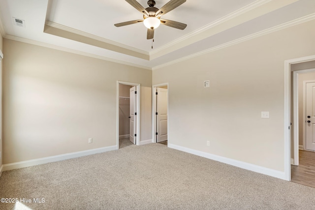 empty room with light carpet, baseboards, and a tray ceiling