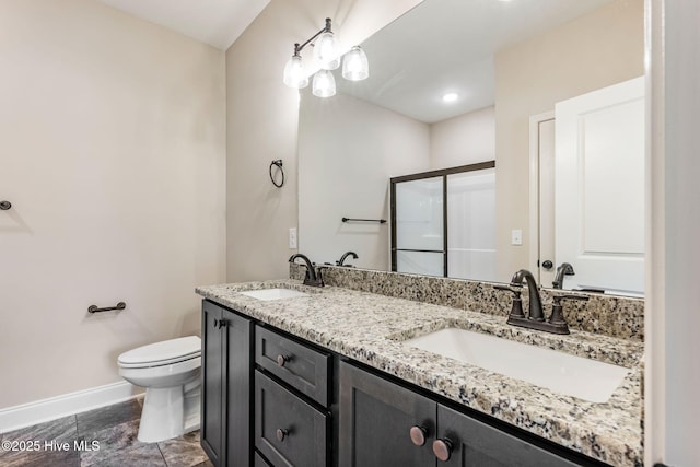 full bathroom featuring baseboards, a sink, toilet, and double vanity