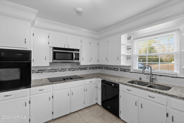 kitchen with white cabinetry, black appliances, sink, and light tile patterned floors