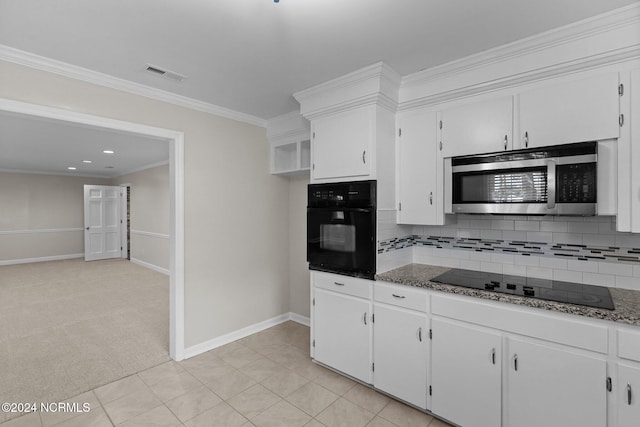 kitchen with white cabinetry, tasteful backsplash, black appliances, and light colored carpet