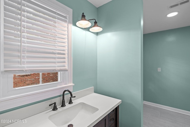 bathroom featuring vanity, hardwood / wood-style flooring, and a healthy amount of sunlight