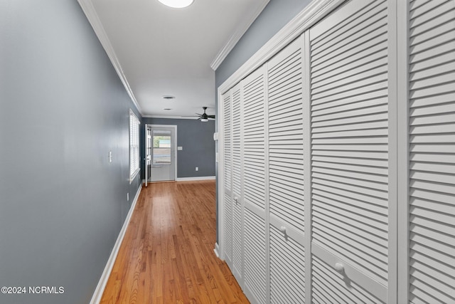 hallway with crown molding and light hardwood / wood-style flooring