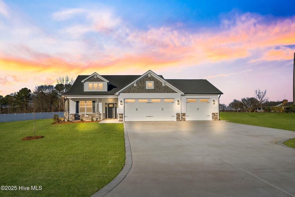 view of front of property featuring a garage and a lawn