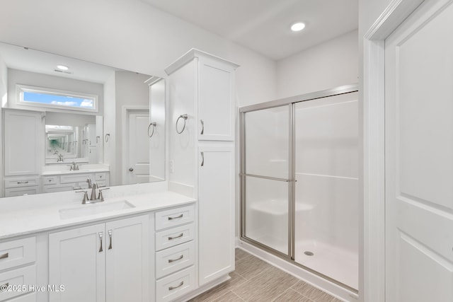 full bathroom with a stall shower, vanity, and recessed lighting