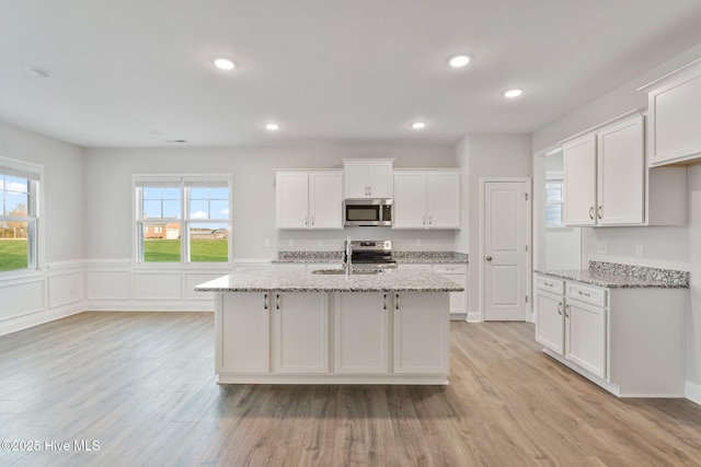 kitchen with recessed lighting, stainless steel appliances, a sink, white cabinets, and light wood-style floors