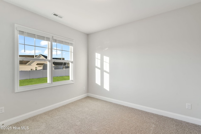 carpeted empty room with visible vents and baseboards