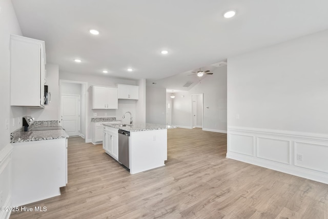 kitchen featuring light wood-style flooring, stainless steel appliances, a sink, white cabinets, and light stone countertops